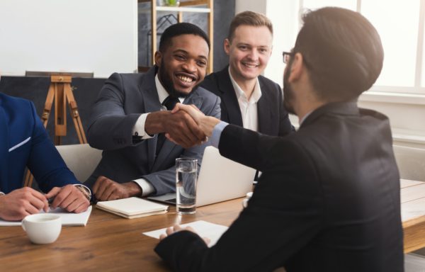 Business handshake at multiethnic office meeting